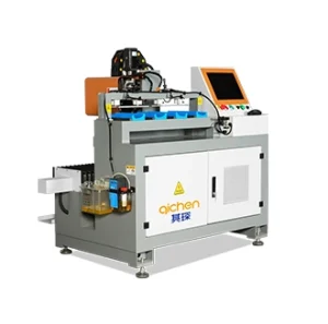 The image shows an automated industrial machine with a control screen and tooling system used for precision manufacturing